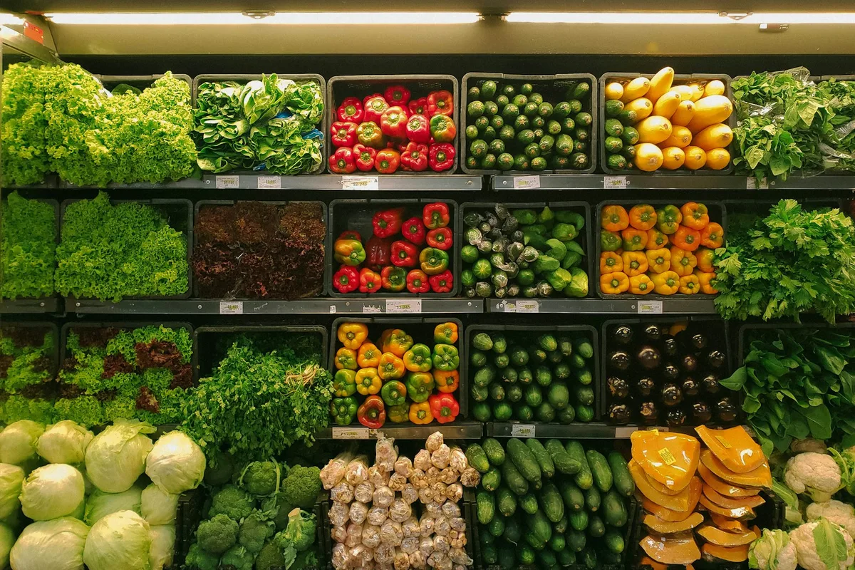 A busy outdoor market with fruit and vegetable stalls